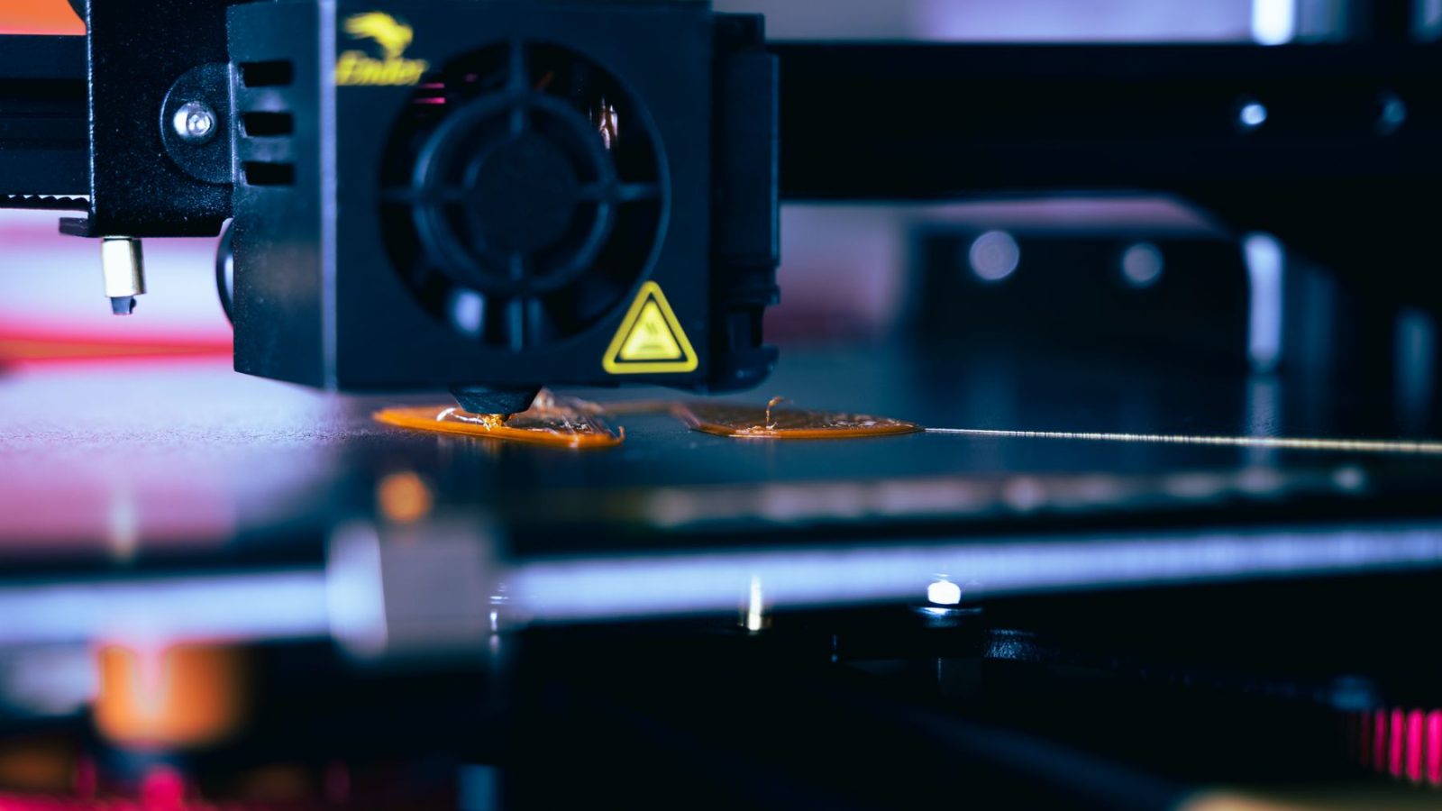 Podroben pogled na glavo 3D tiskalnika med delovanjem, ki prikazuje sodobno tehnologijo tiskanja
