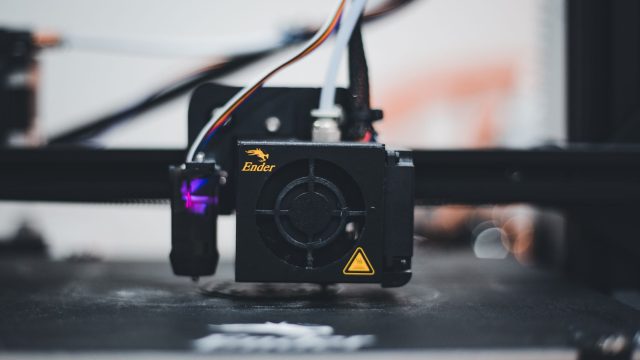Detailed view of a 3D printer nozzle during the printing process, showcasing advanced technology