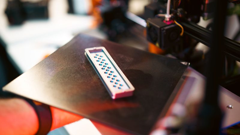 Close-up of a 3D printed part on an industrial printer in a workshop setting